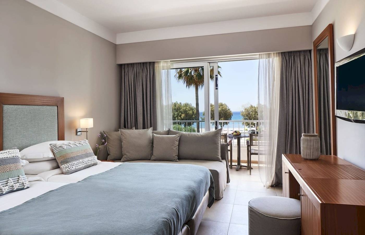 Zimmer im Atlantica Beach Resort Kos mit Blick auf das Meer und einen Balkon.