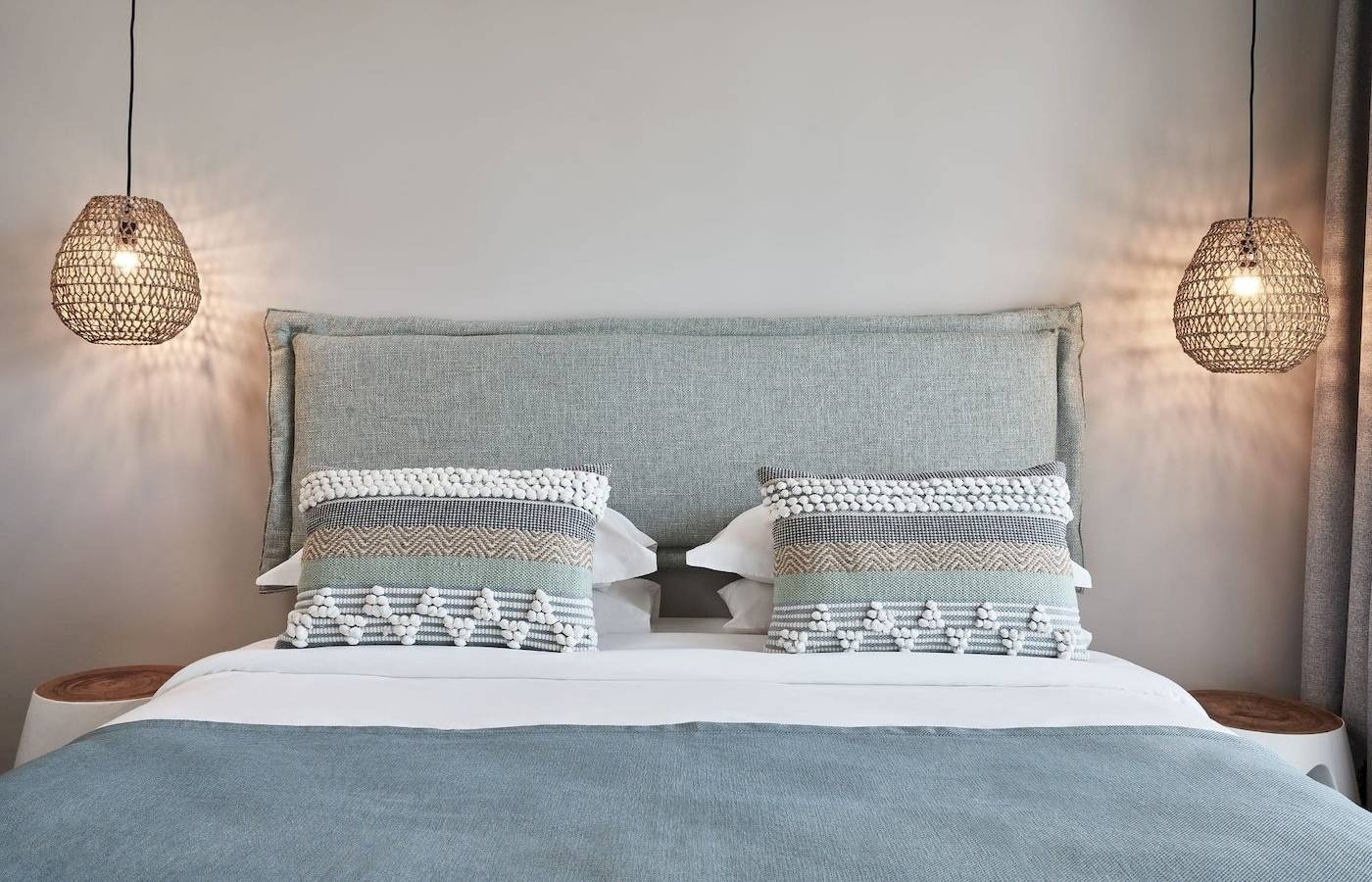 Schlafzimmer im Atlantica Beach Resort Kos mit einem Bett, Kissen, und dekorativen Lampen.