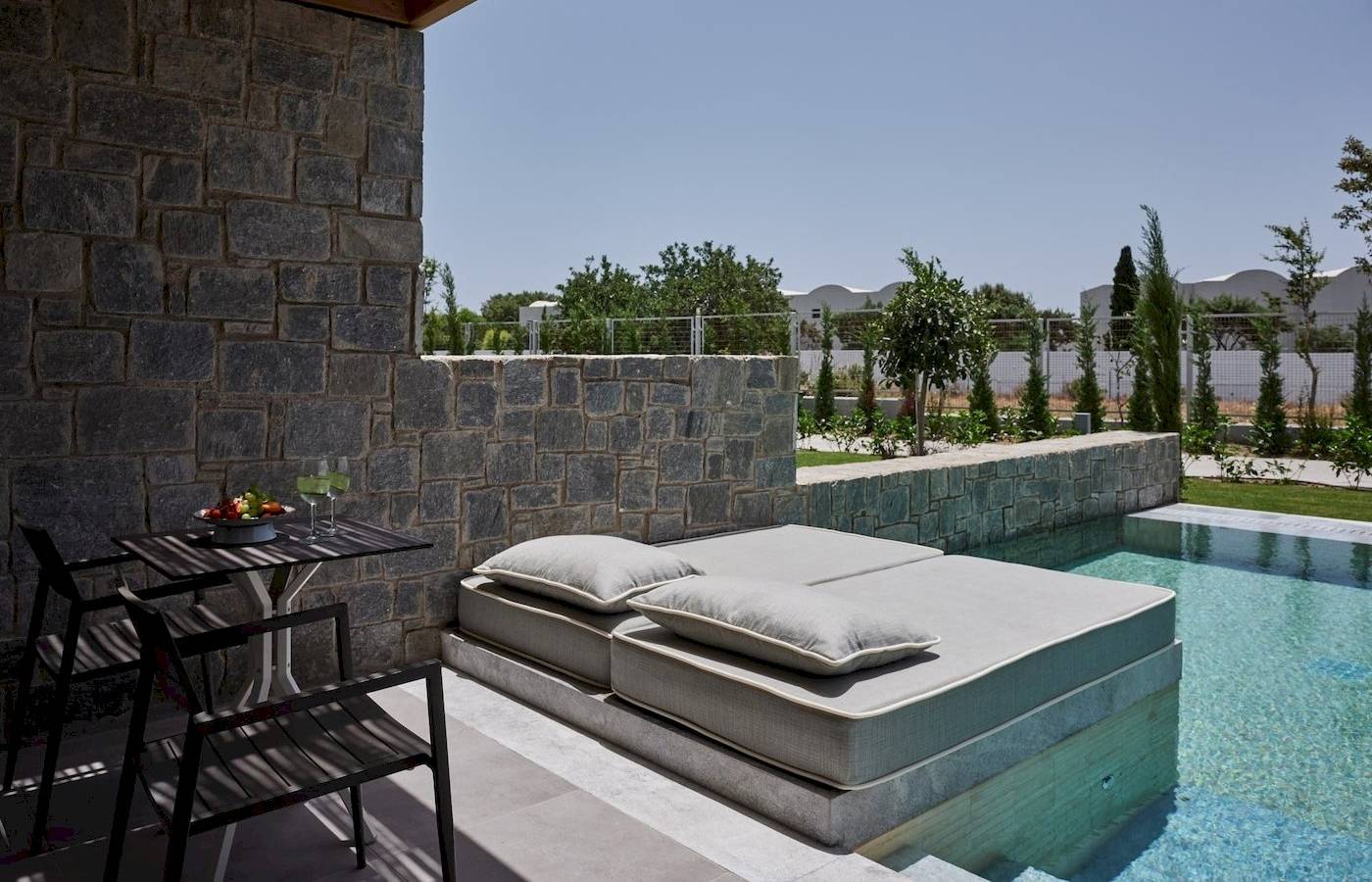 Terrasse im Atlantica Beach Resort Kos mit Liegebett und Swimmingpool.