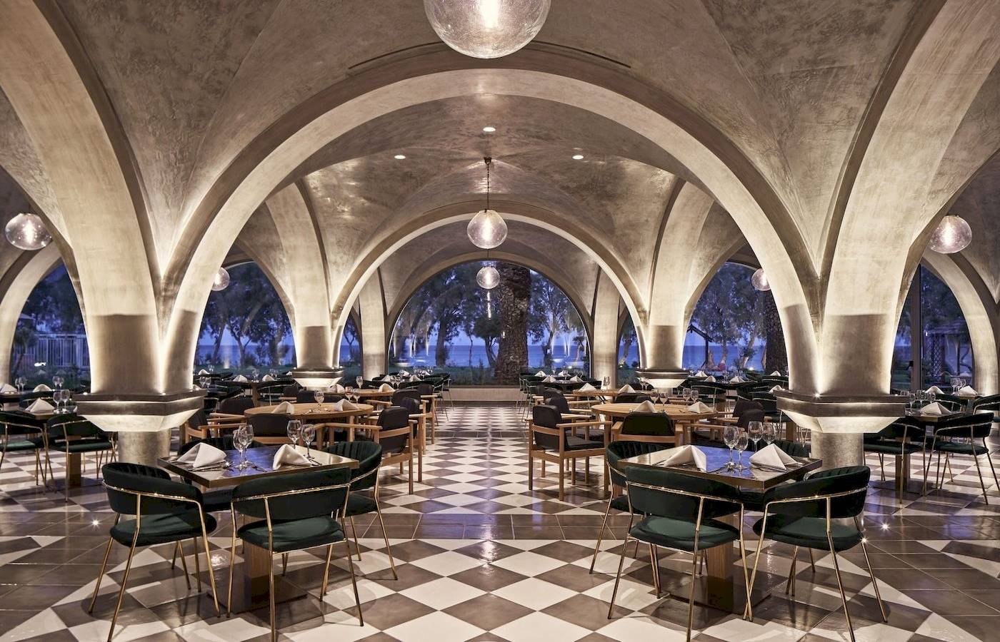 Restaurant-Innenansicht des Atlantica Beach Resort Kos mit bogenförmigen Decken und schachbrettartigem Boden.