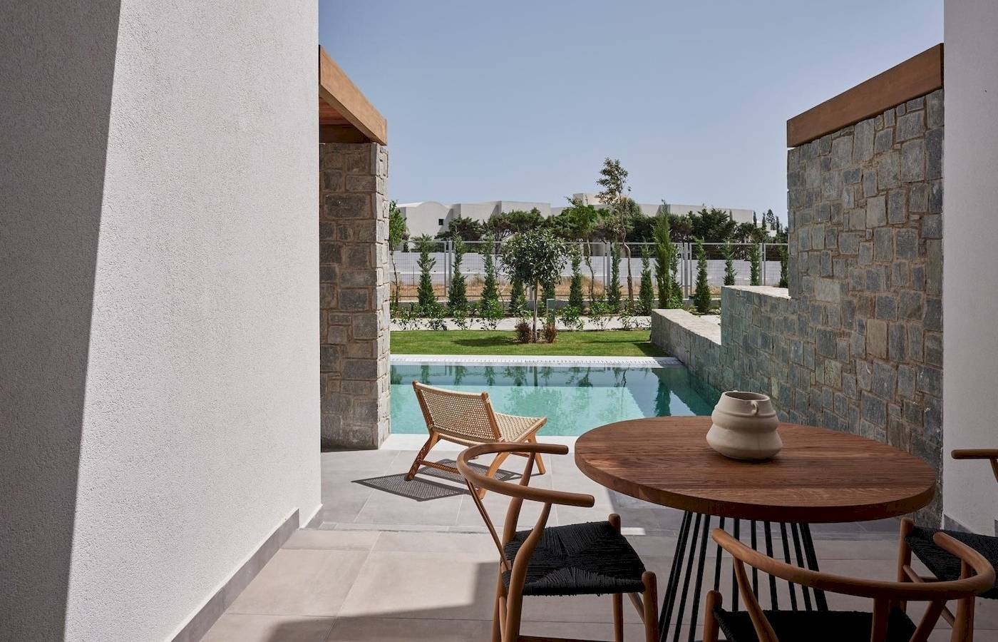 Terrasse mit Tisch und Stühlen und Blick auf den Pool im Atlantica Beach Resort Kos