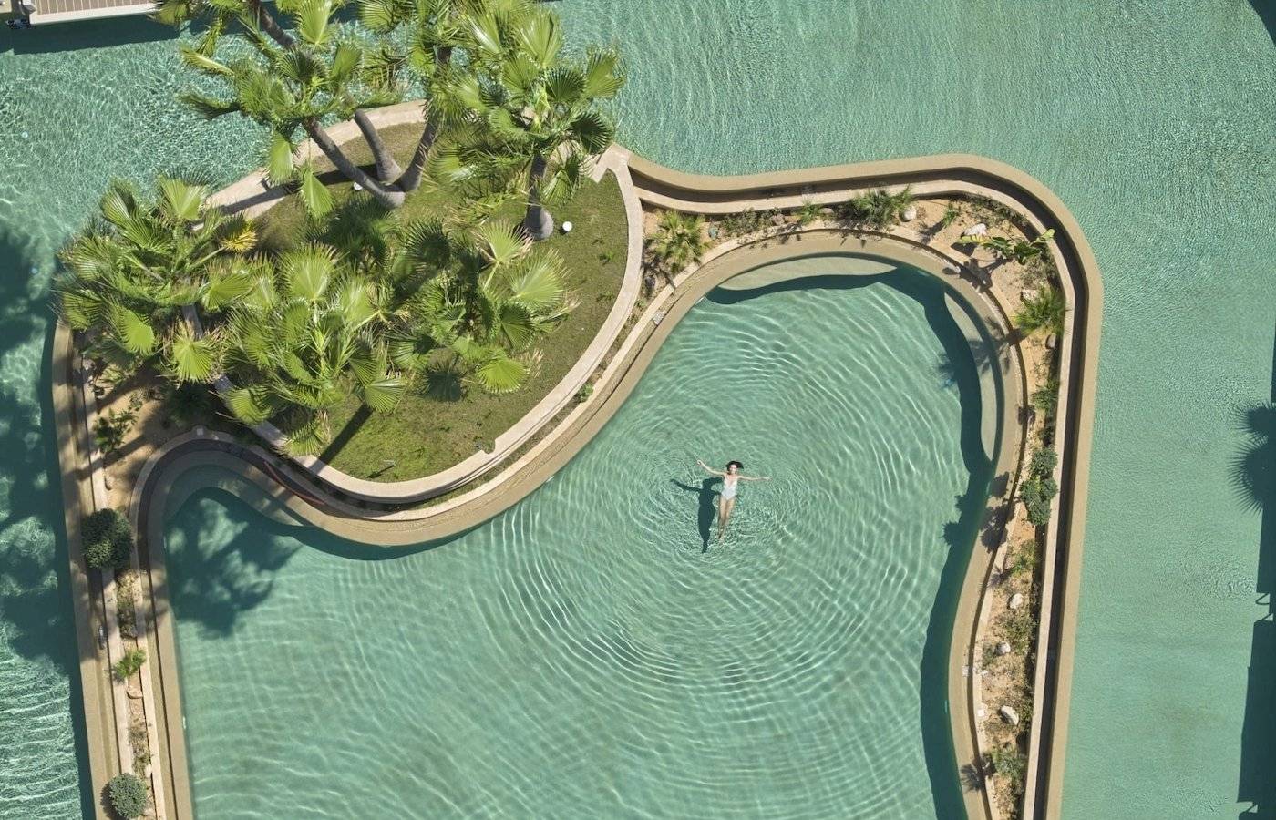 Person schwimmt in der Infinity-Pool-Landschaft des Atlantica Beach Resort Kos.