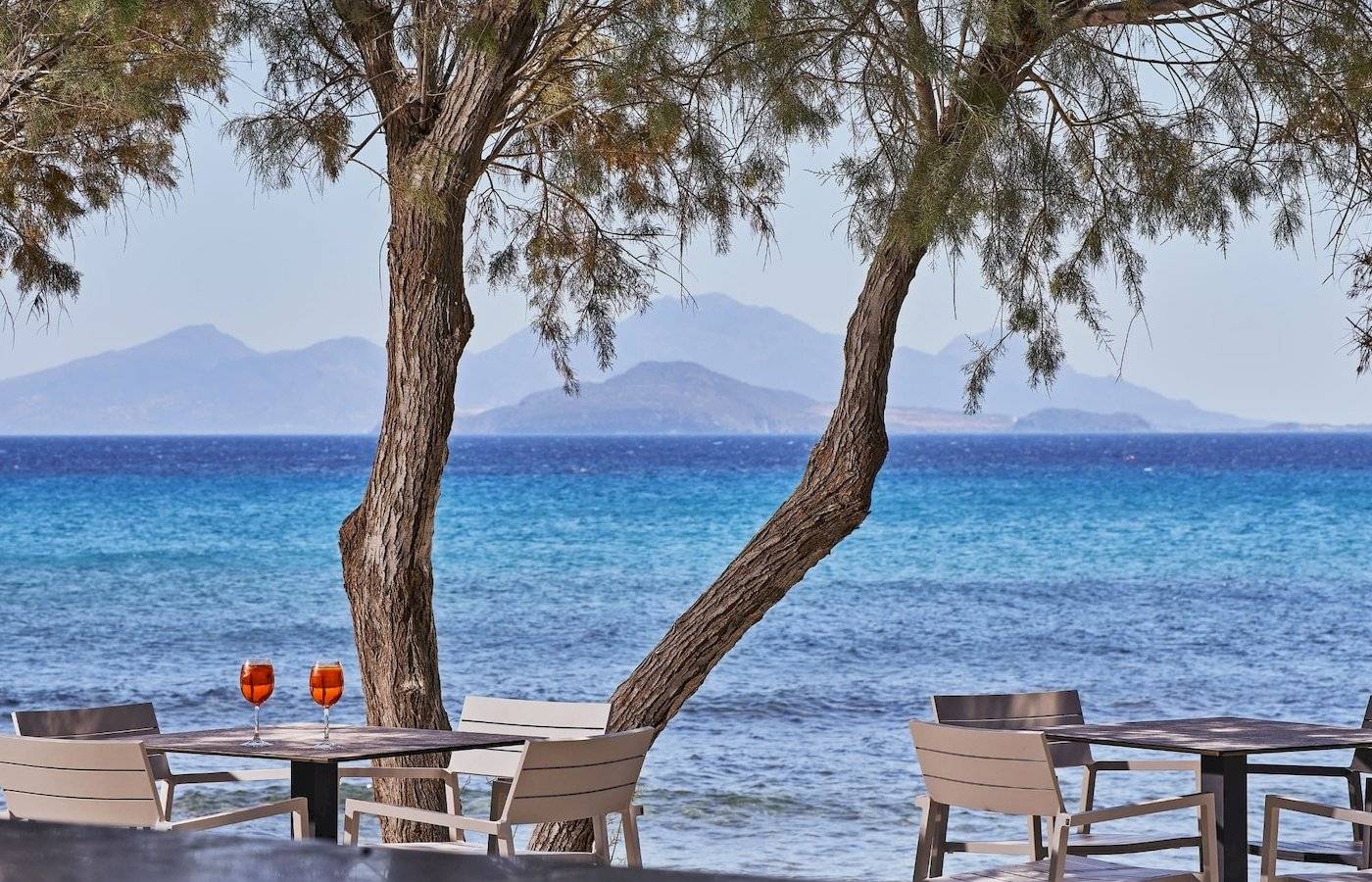 Terrasse des Atlantica Beach Resort Kos mit Tischen und Getränken vor dem Meer