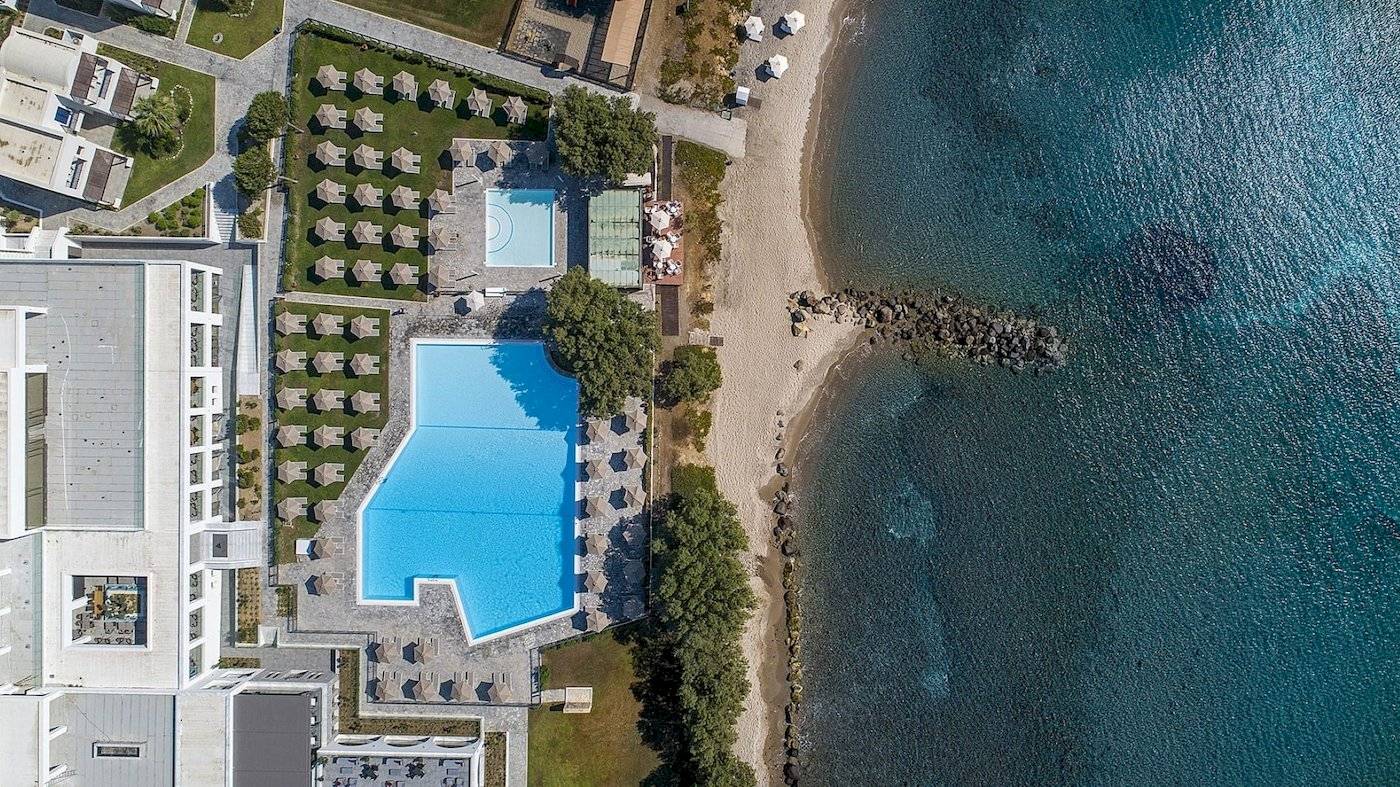 Oberansicht des Atlantica Beach Resort Kos mit Swimmingpool und Sonnenschirmen.