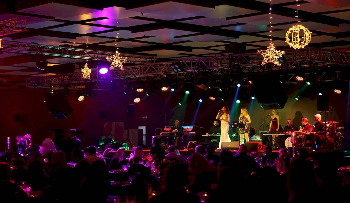 Veranstaltung im Nirvana Cosmopolitan Hotel mit Band, Lichterketten und Publikum.