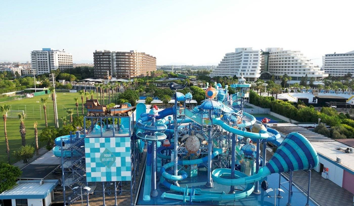 Luftaufnahme des Nirvana Cosmopolitan Wasserparks mit vielen Rutschen und Gebäuden im Hintergrund.