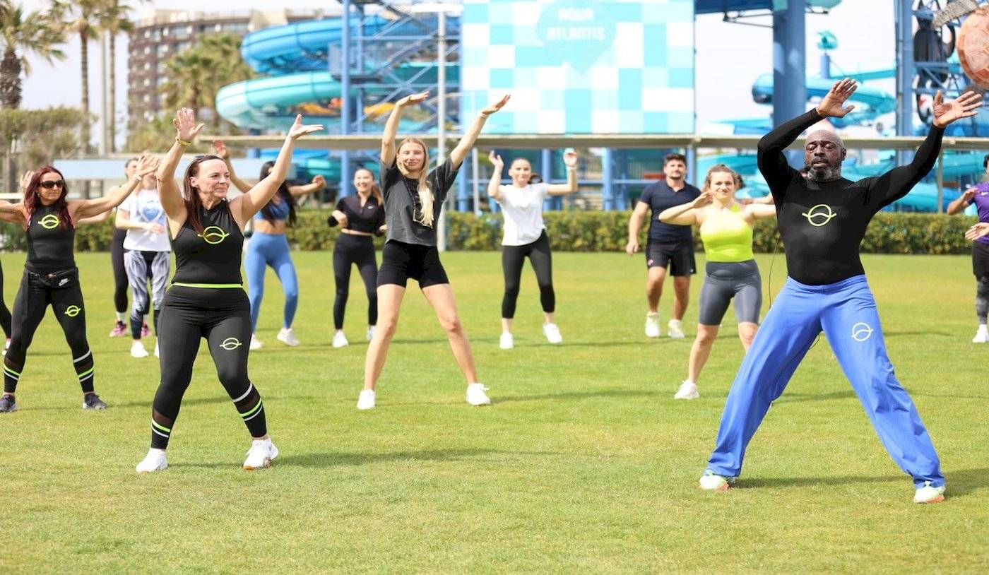 Fitnessgruppe im Nirvana Cosmopolitan Hotelgarten vor einer Wasserrutsche