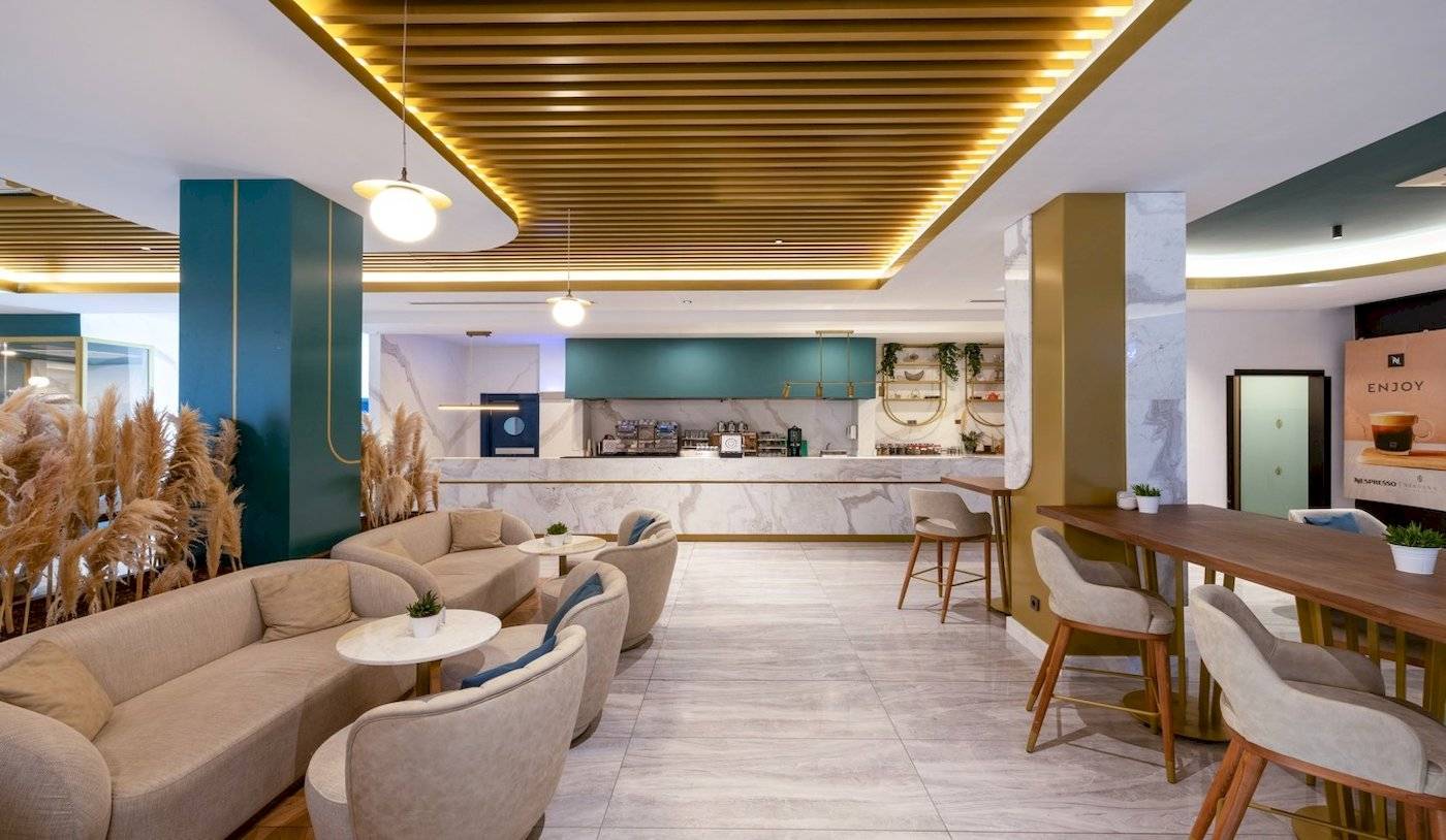 Loungebereich des Nirvana Cosmopolitan Hotels mit modernen Möbeln und einer Bar.