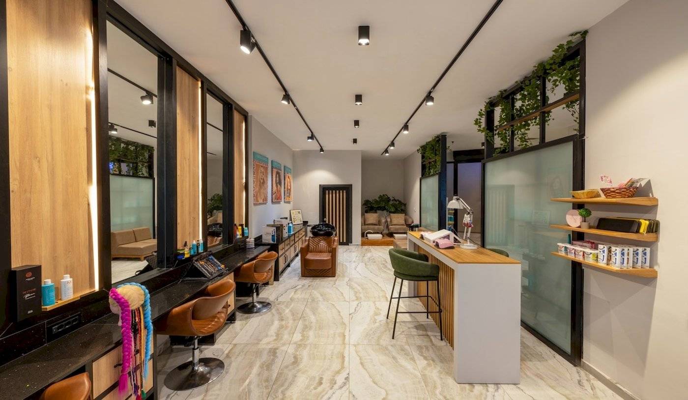 Innenansicht des Nirvana Cosmopolitan Hotels mit Friseursalon, Spiegeln, Stühlen und Empfangstresen.