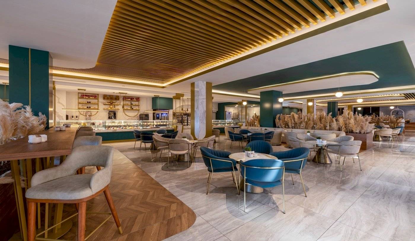 Innenbereich des Nirvana Cosmopolitan Hotels mit modernen Möbeln, grünen Wänden und Holzboden.