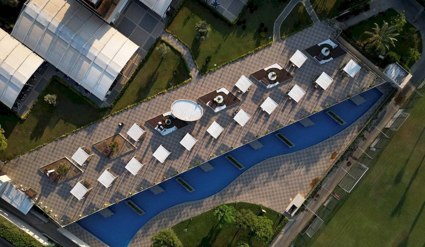 Luftaufnahme der Terrasse im Nirvana Cosmopolitan Hotel mit Pool und Lounge-Bereichen.