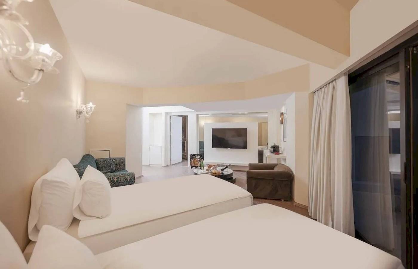 Doppelzimmer im Megasaray Resort Side mit zwei Betten, Fernseher und Sofa.