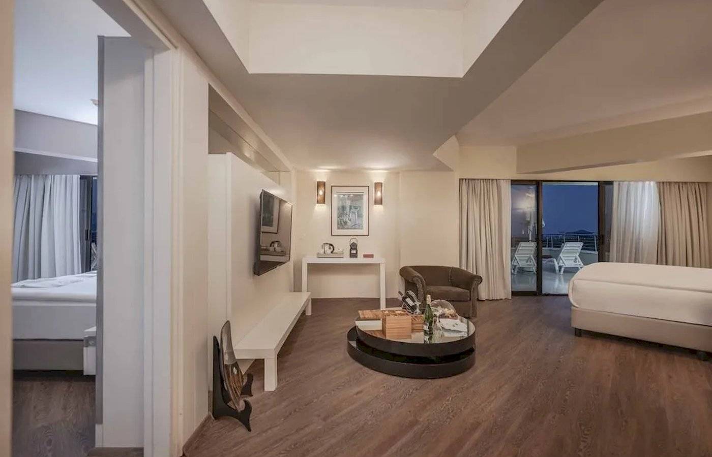 Innenansicht einer Hotelsuite im Megasaray Resort Side mit Wohnzimmer, Schlafzimmer und Balkon.