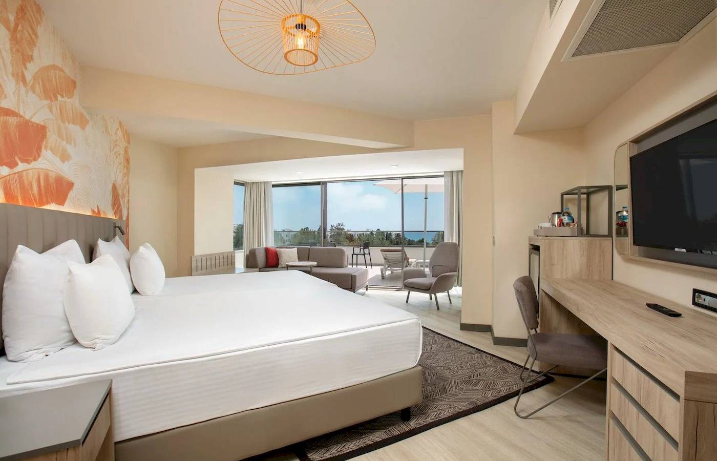 Hotelzimmer im Megasaray Resort Side mit großem Bett, Wohnzimmerbereich und Blick auf den Balkon.