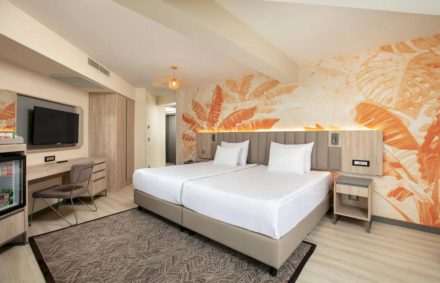 Doppelzimmer im Megasaray Resort Side mit zwei Betten, Fernseher, Schreibtisch und tropischen Wandmustern.