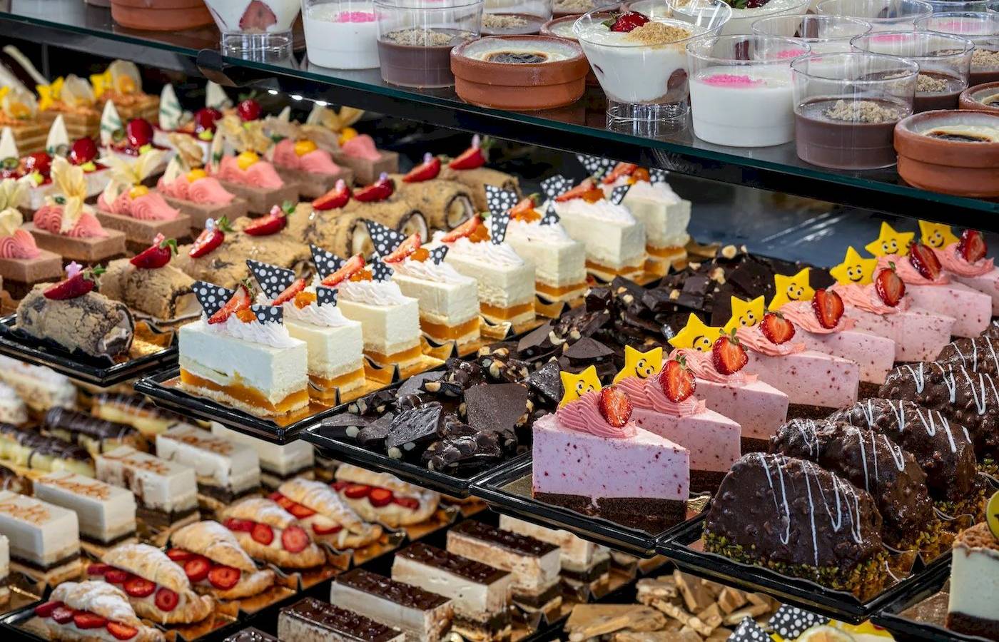 Megasaray Resort Side präsentiert eine Auswahl an Desserts in einem Display.