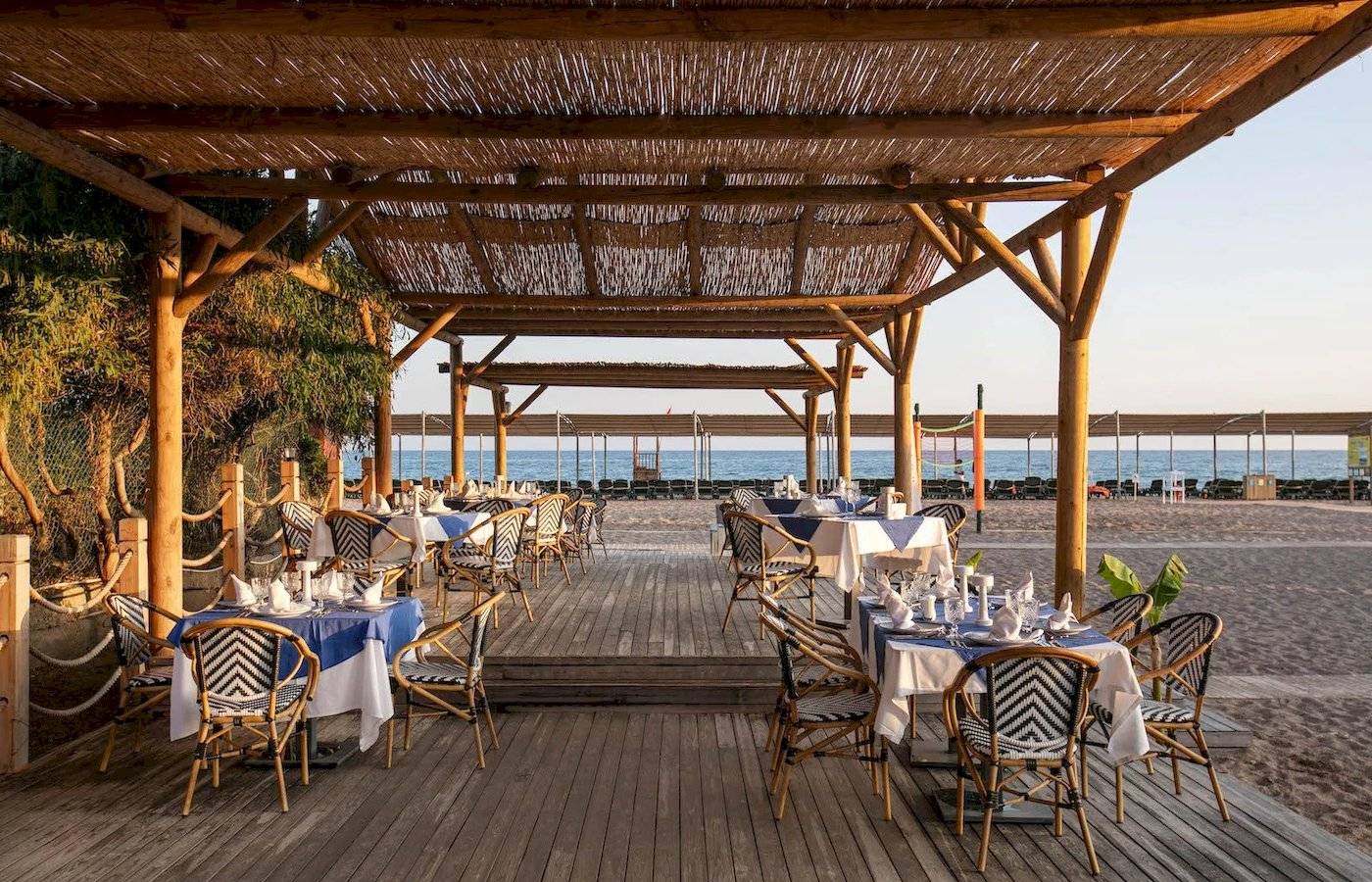 Restaurant am Strand des Megasaray Resorts in Side mit gedeckten Tischen und Stühlen.