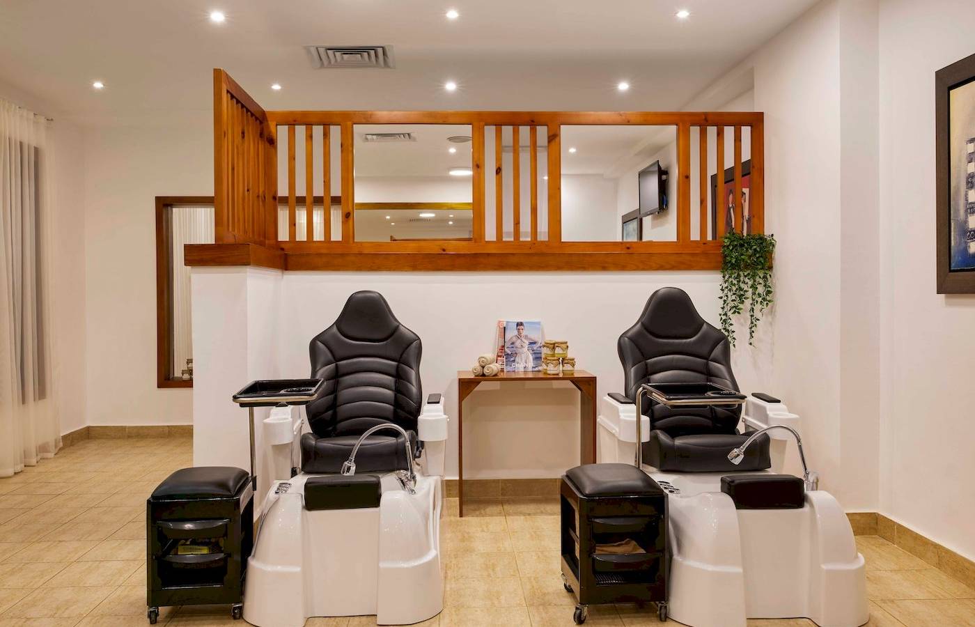 Innenbereich des Schönheitssalons im Jaz Grand Marsa Hotel mit zwei Fußpflegestühlen und einer kleinen Tischkonsole.