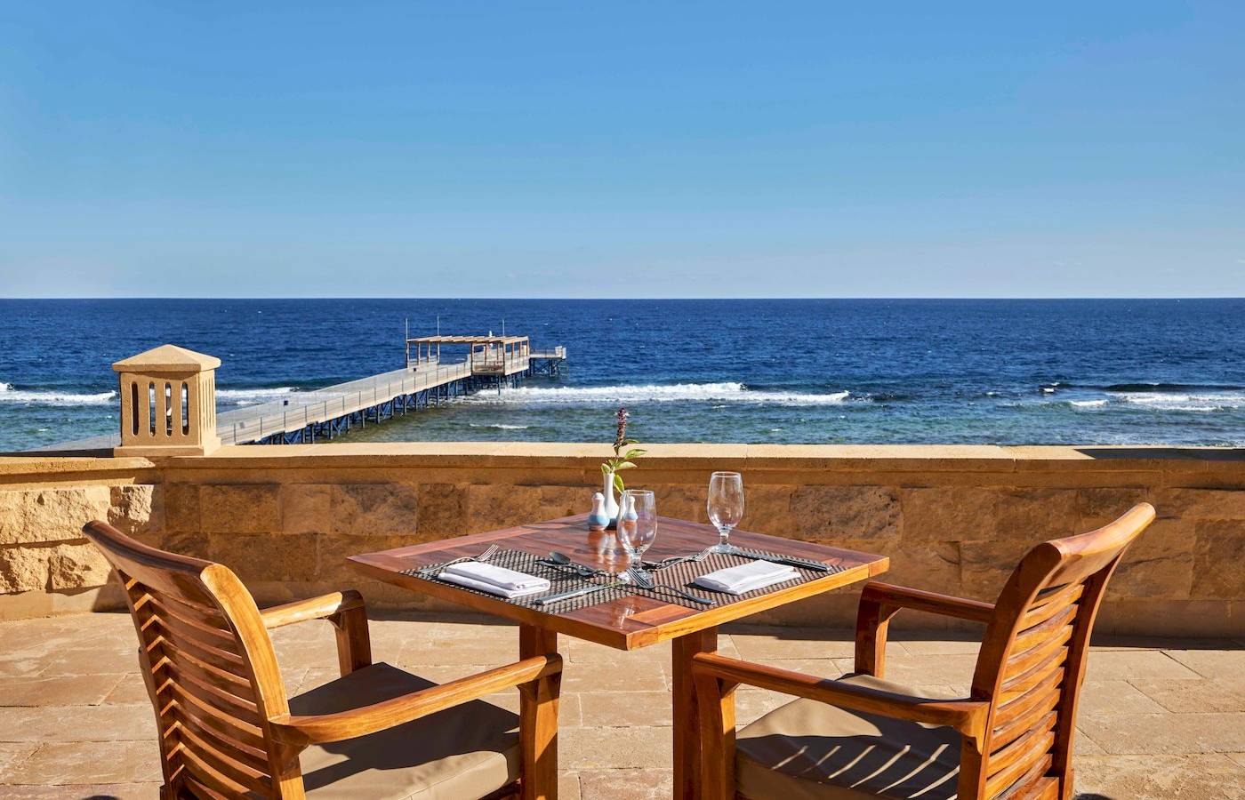 Außenbereich des Jaz Grand Marsa mit Blick auf das Meer und eine Brücke.