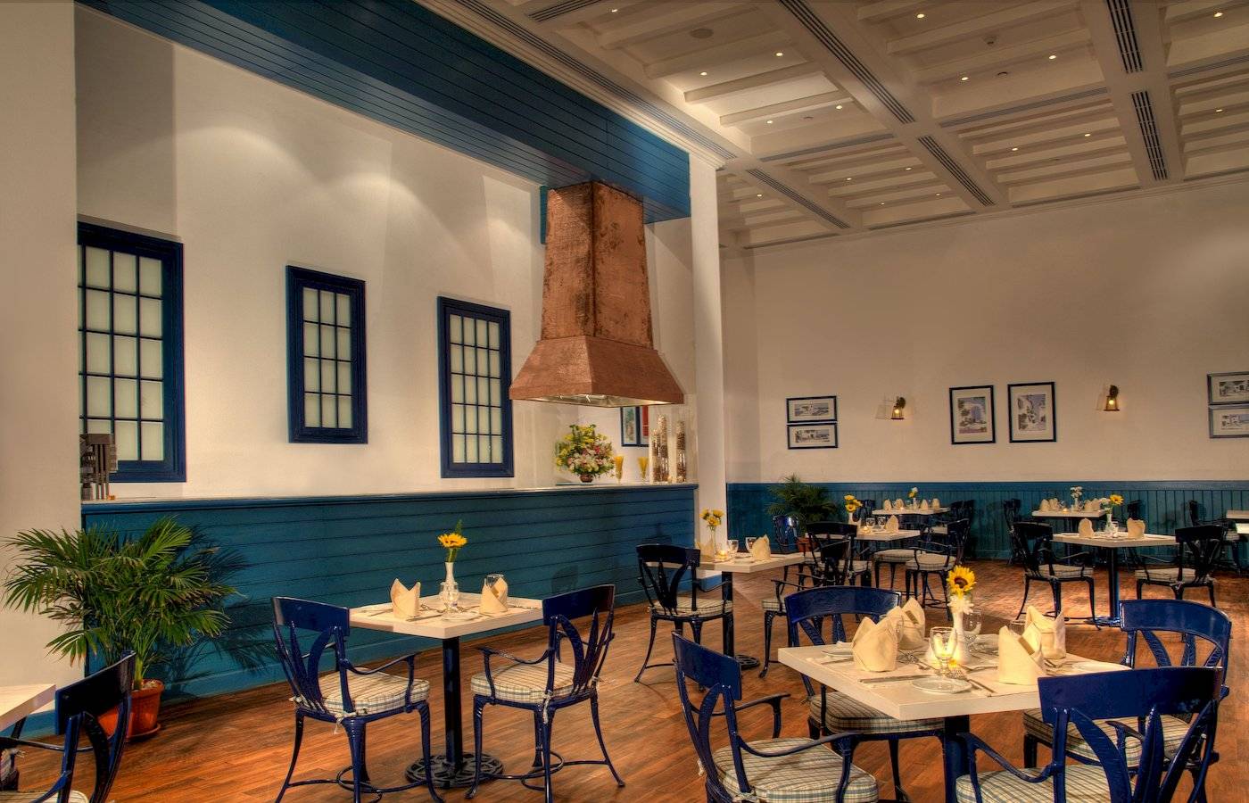 Innenbereich des Jaz Grand Marsa Restaurants mit blauen Stühlen und Tischen.