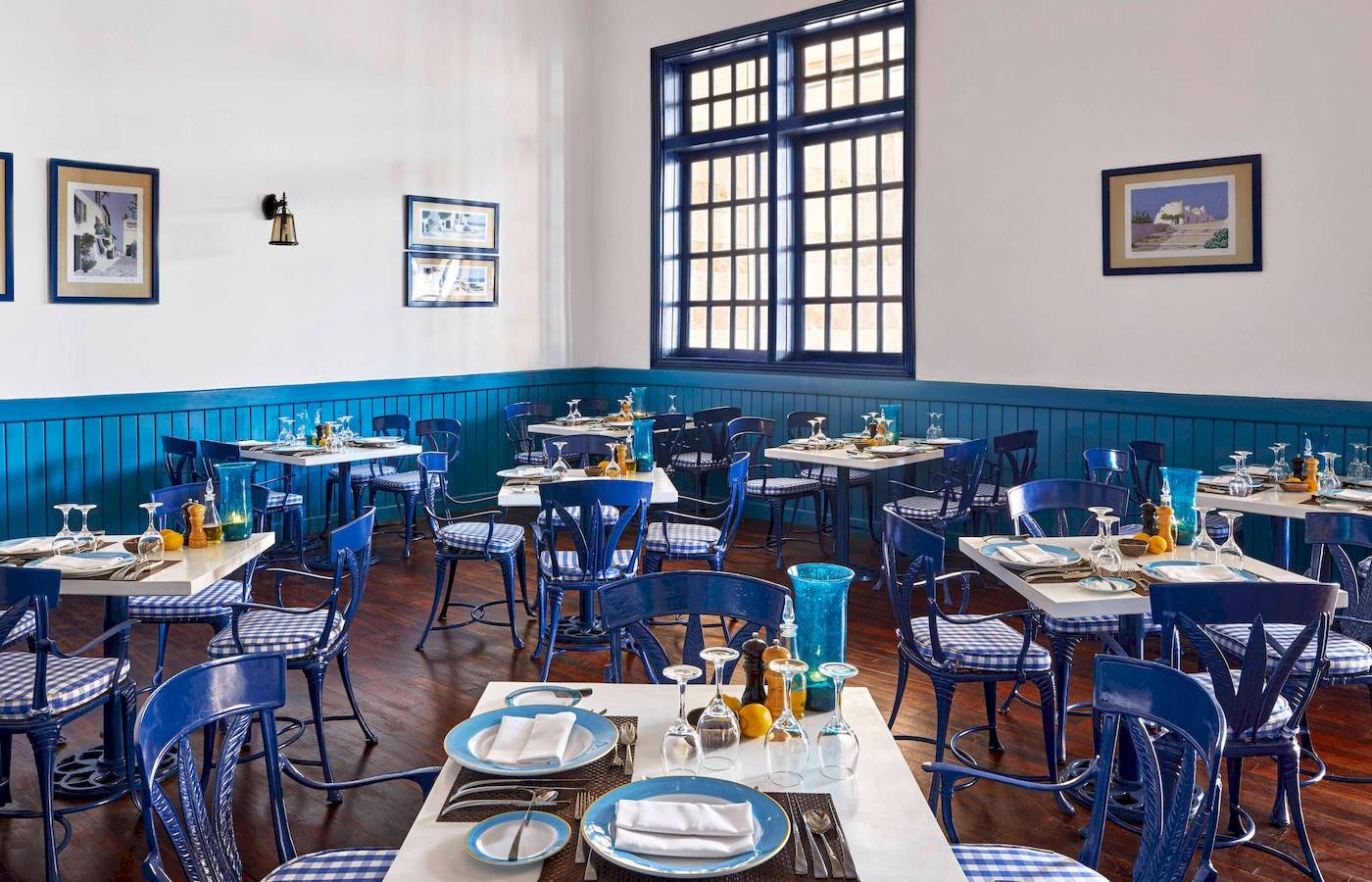 Innenansicht des Restaurants im Jaz Grand Marsa Hotel mit blauen Stühlen und Tischen.