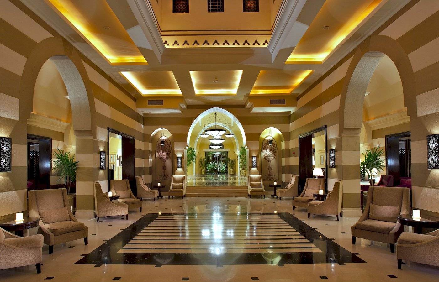 Empfangsbereich des Jaz Lamaya Resorts mit gepolsterten Stühlen und Tischlampen.