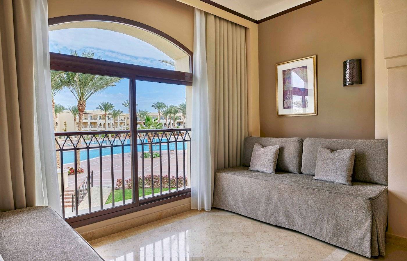 Suite im Jaz Lamaya Resort mit Balkon und Blick auf den Pool.