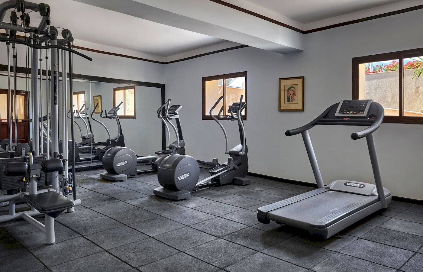 Fitnesscenter im Jaz Lamaya Resort mit mehreren Geräten und Fenstern.
