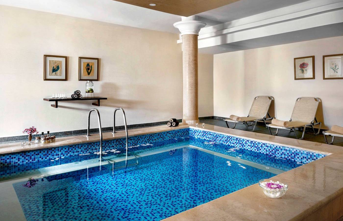 Ein Schwimmbad im Jaz Lamaya Resort mit blauen Fliesen und Liegestühlen.