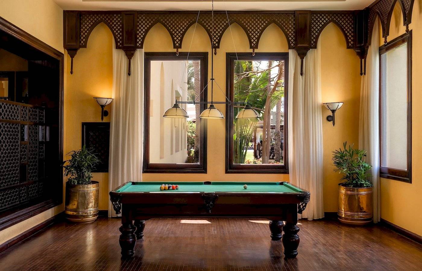 Pooltisch im Jaz Lamaya Resort mit gelben Wänden und großen Fenstern.