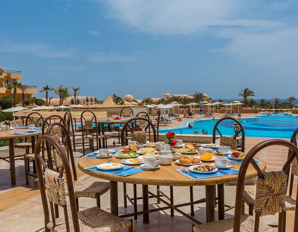 Frühstückstisch am Pool im Utopia Beach Club mit Blick auf das Meer.
