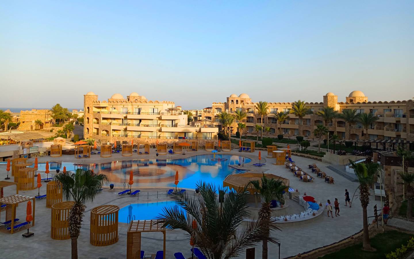 Aussicht auf das Utopia Beach Club Resort mit Swimmingpool, Lounge-Bereichen und Gebäuden.