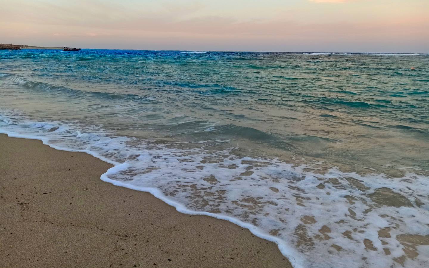 Foto vom Utopia Beach Club zeigt das Meer am Abend mit sanften Wellen am Strand.