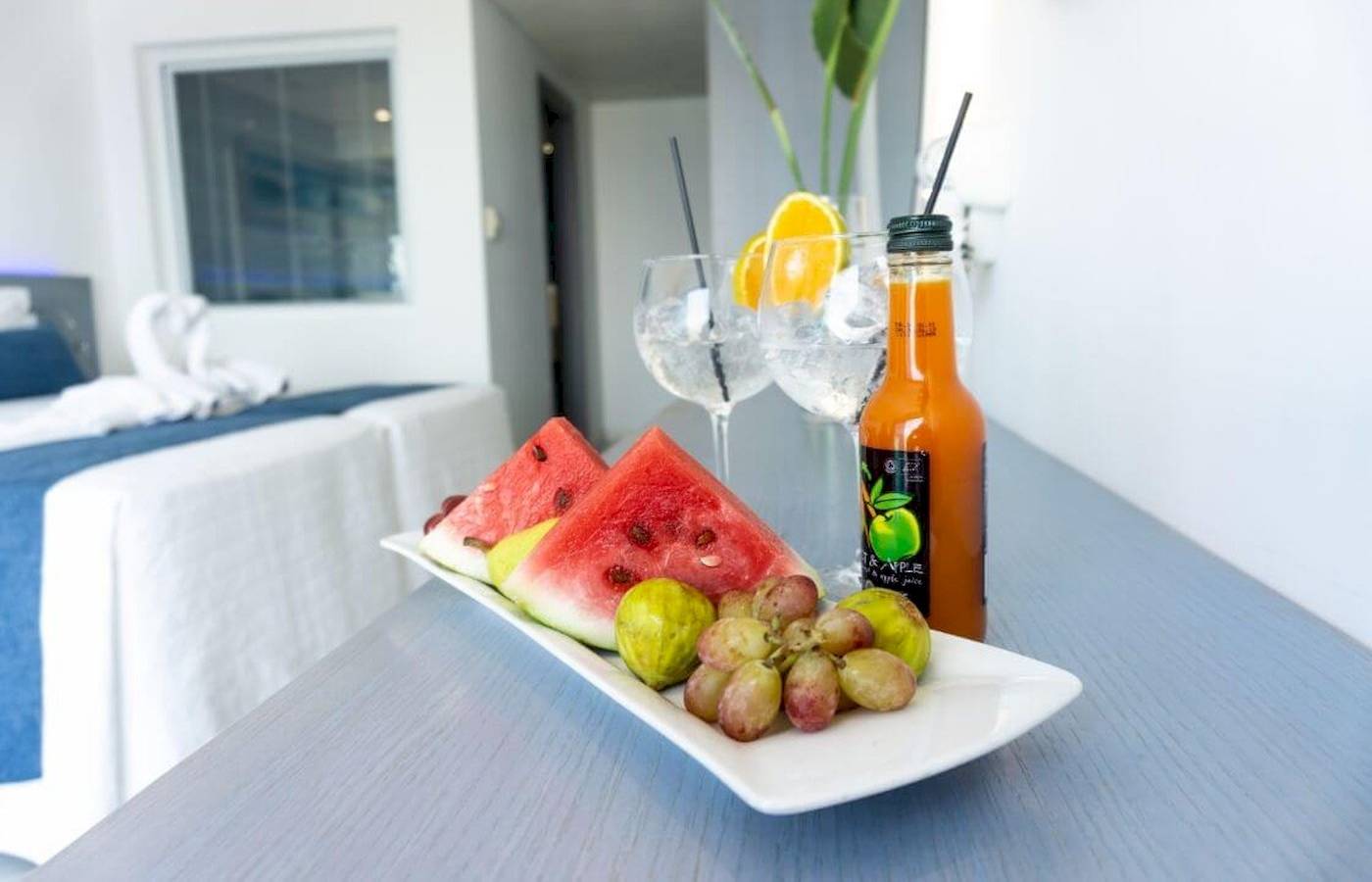 Frühstücksplatte mit Wassermelonen, Feigen, Trauben und Getränken im Anonymous Beach Hotel.