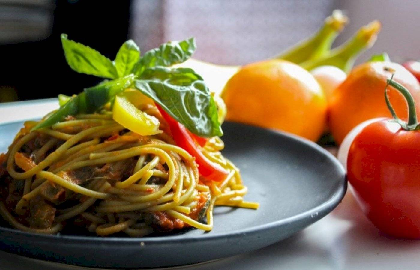 Spaghetti-Gericht mit Gemüse auf einem Teller serviert.