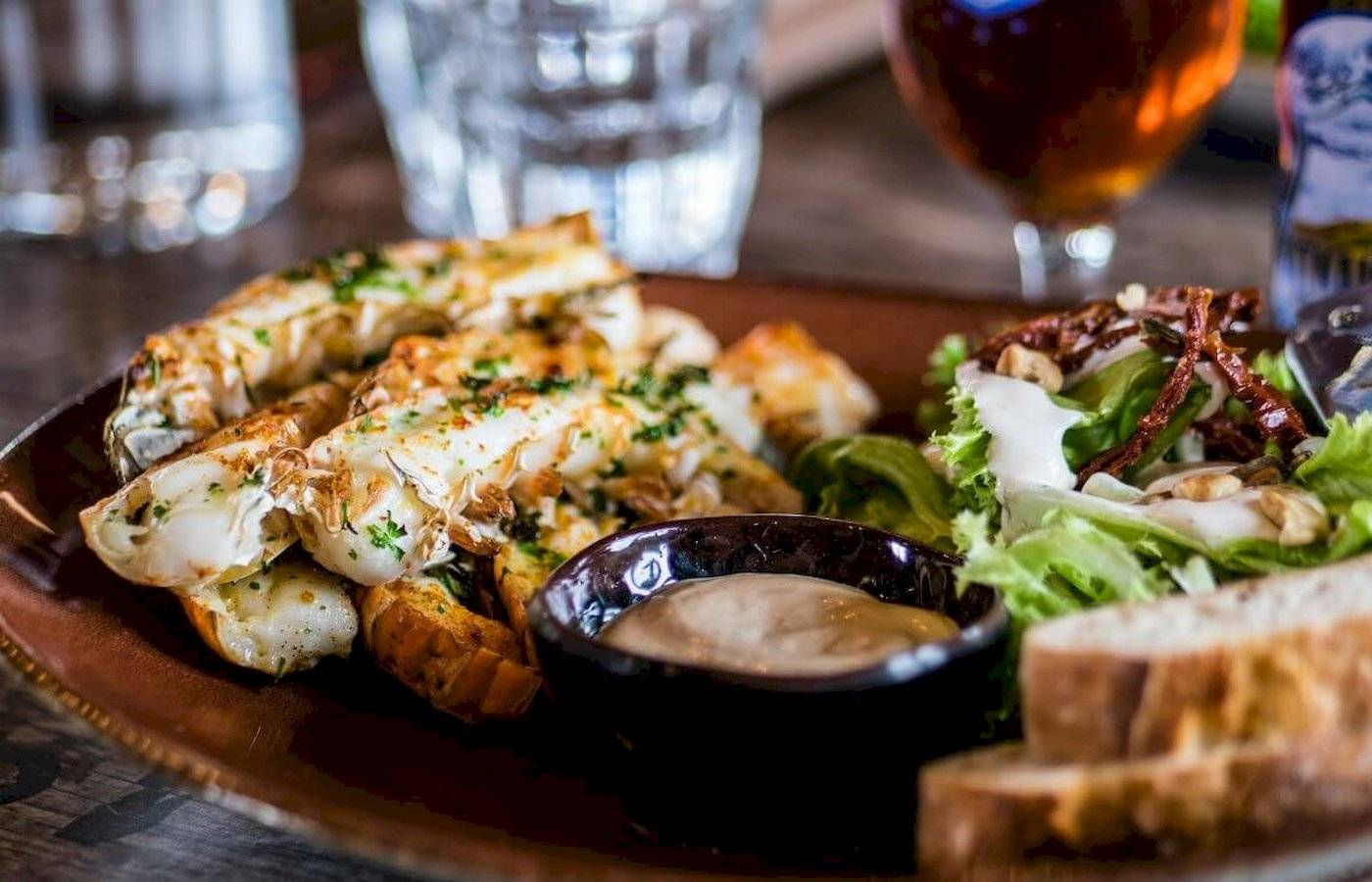 Gericht auf einer Platte im Anonymous Beach Hotel mit Salat, Brot und Sauce.