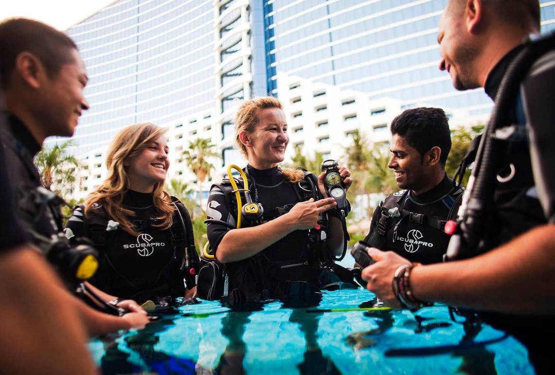 Gruppe von Tauchern bereitet sich vor dem Jumeirah Beach Hotel vor.