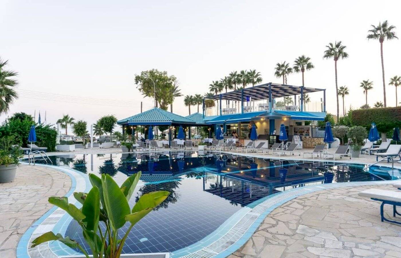 Außenpool des Anonymous Beach Hotels mit Lounge-Stühlen und Sonnenschirmen.