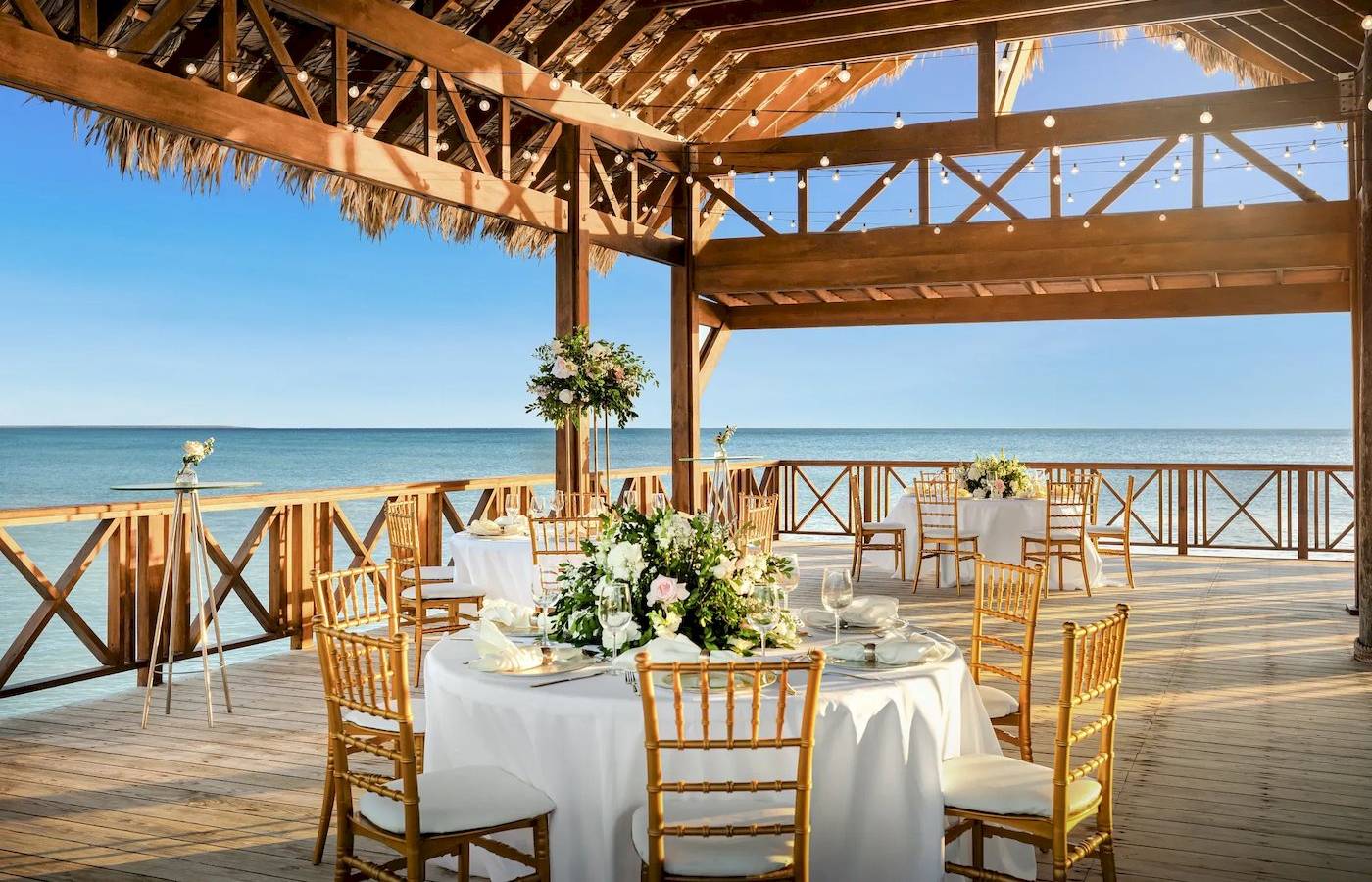 Foto von der Terrasse des Sunscape Dominicus La Romana mit Blick auf das Meer und gedeckten Tischen.