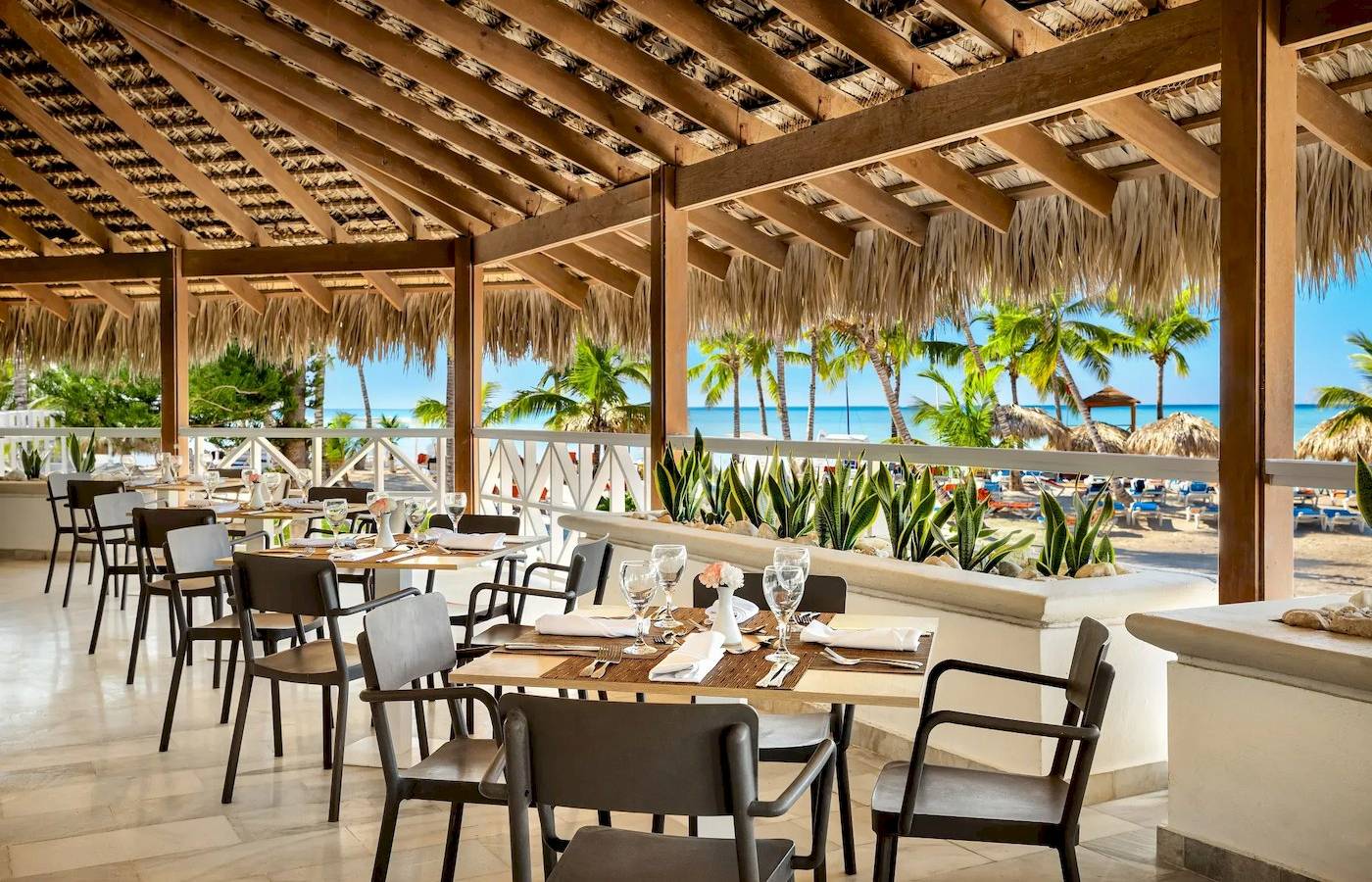 Restaurantterrasse des Sunscape Dominicus La Romana mit Blick auf den Strand und das Meer.