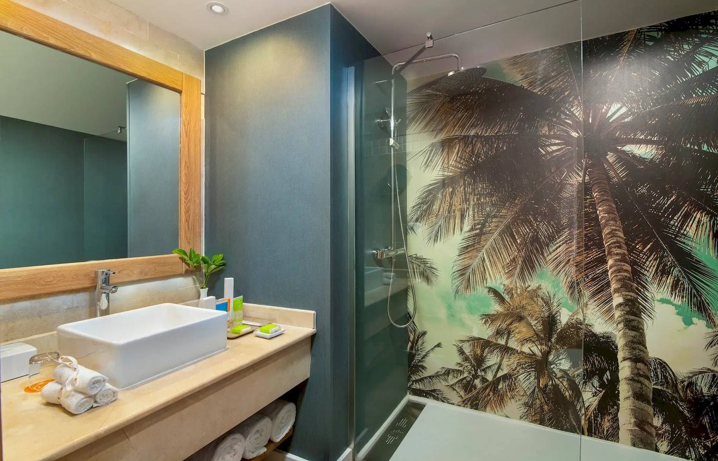 Badezimmer im Sunscape Dominicus La Romana Hotel mit Palmentapete und blauen Wänden.