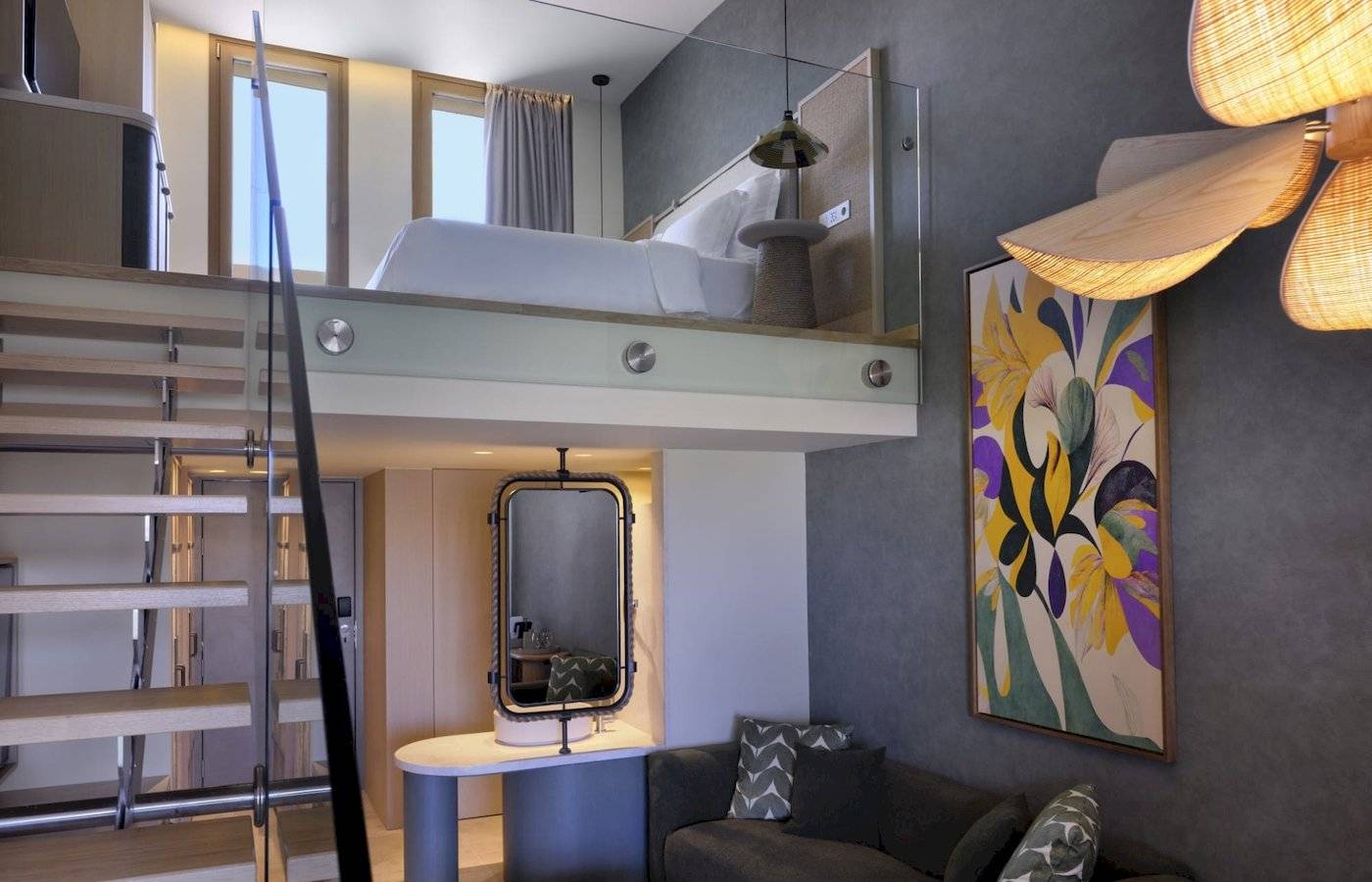 Innenansicht eines Zimmers im Atlantica Kalliston Resort mit hoher Decke, Doppelbett und Wohnzimmerbereich.