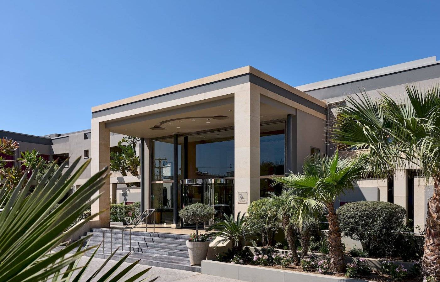 Außenansicht des Atlantica Kalliston Resorts mit moderner Architektur und Eingangsbereich.