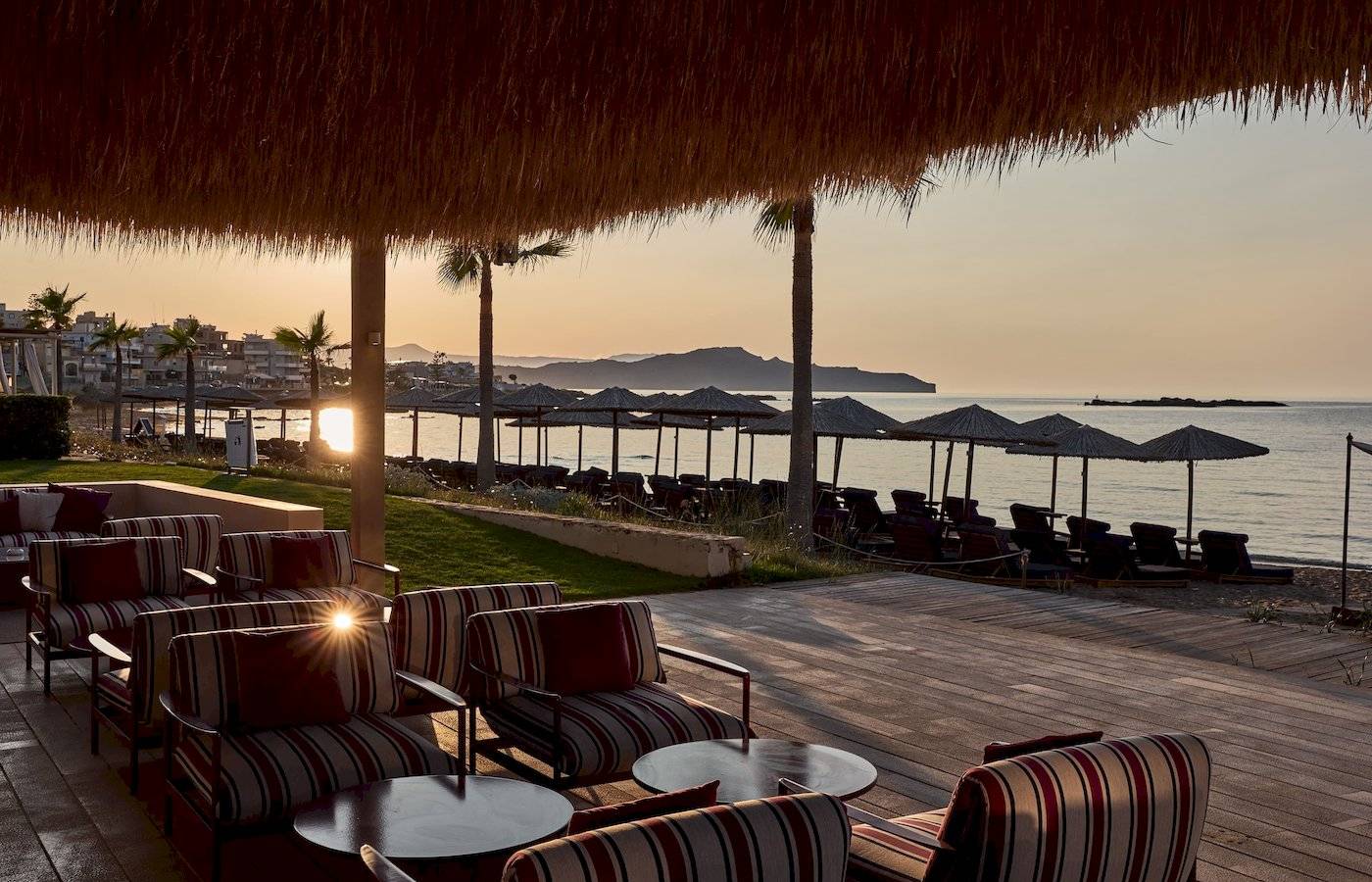 Aussicht auf die Terrasse des Atlantica Kalliston Resorts mit Sonnenuntergang am Meer.