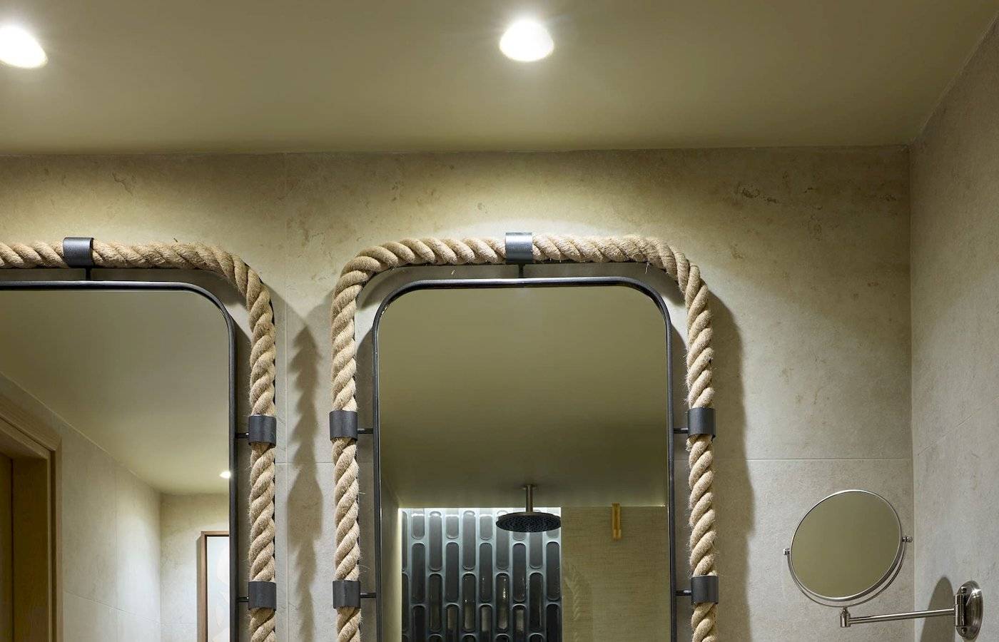 Badezimmer des Atlantica Kalliston Resorts mit zwei Waschbecken und Spiegeln.