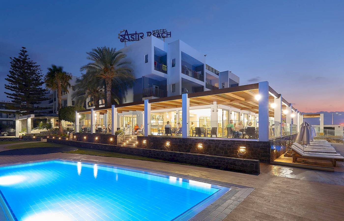 Pool im Freien neben dem Astir Beach Hotel in Kreta, das bei Nacht geöffnet ist.