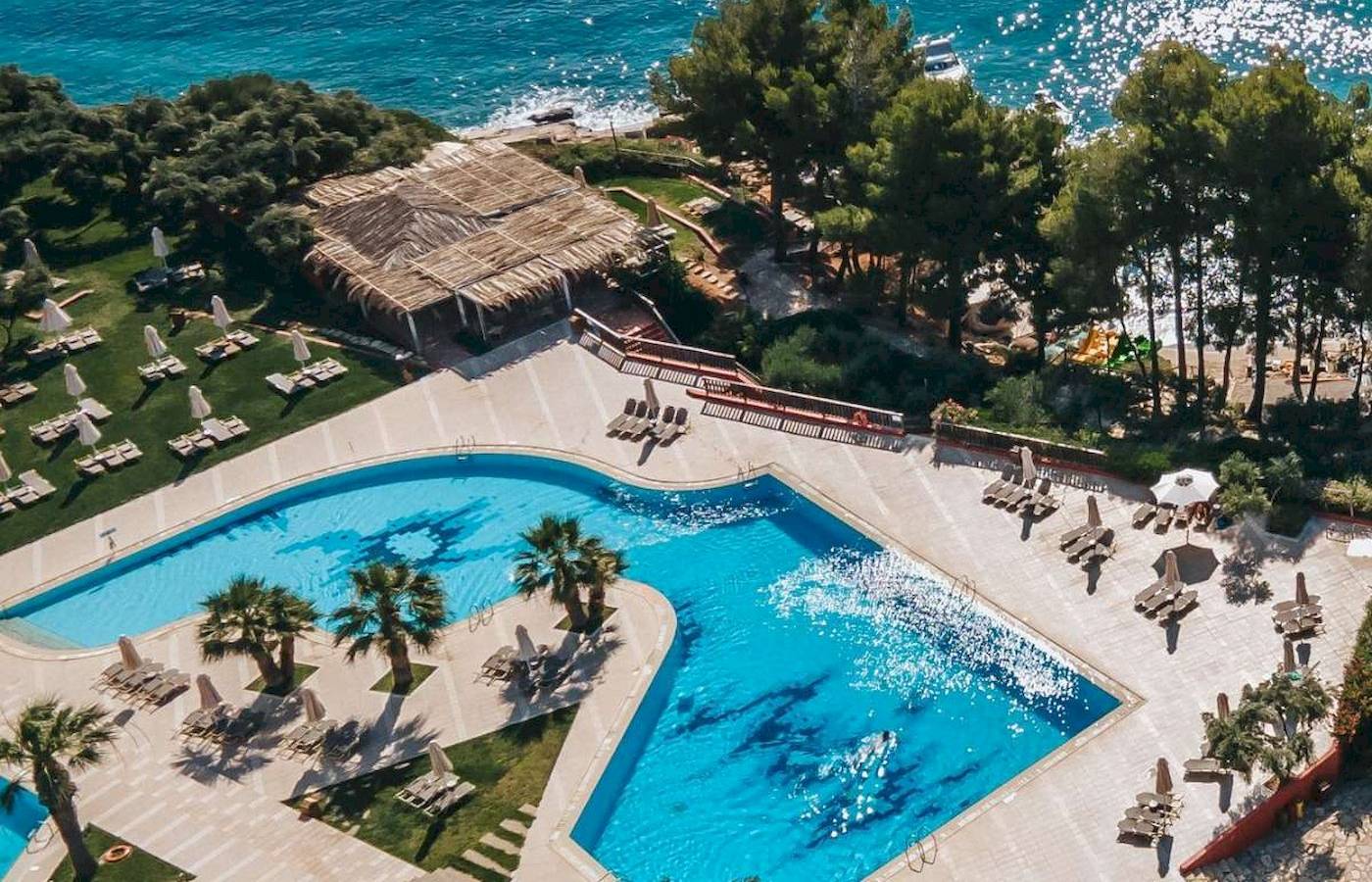 Luftaufnahme des Candia Park Village Hotels mit Swimmingpool und Blick auf das Meer.