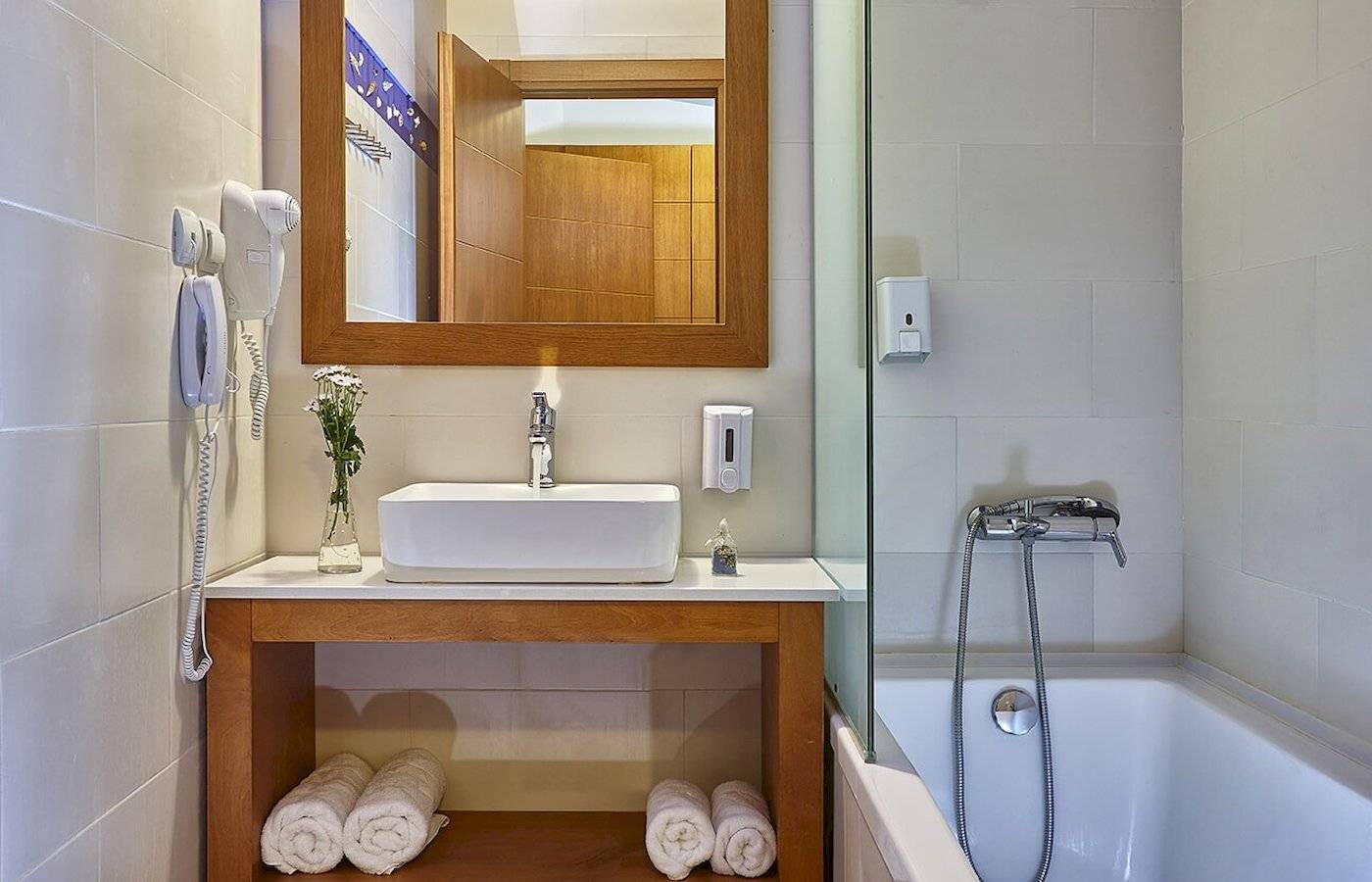 Badezimmer im Arminda Hotel & Spa mit Badewanne, Waschbecken und Handtüchern