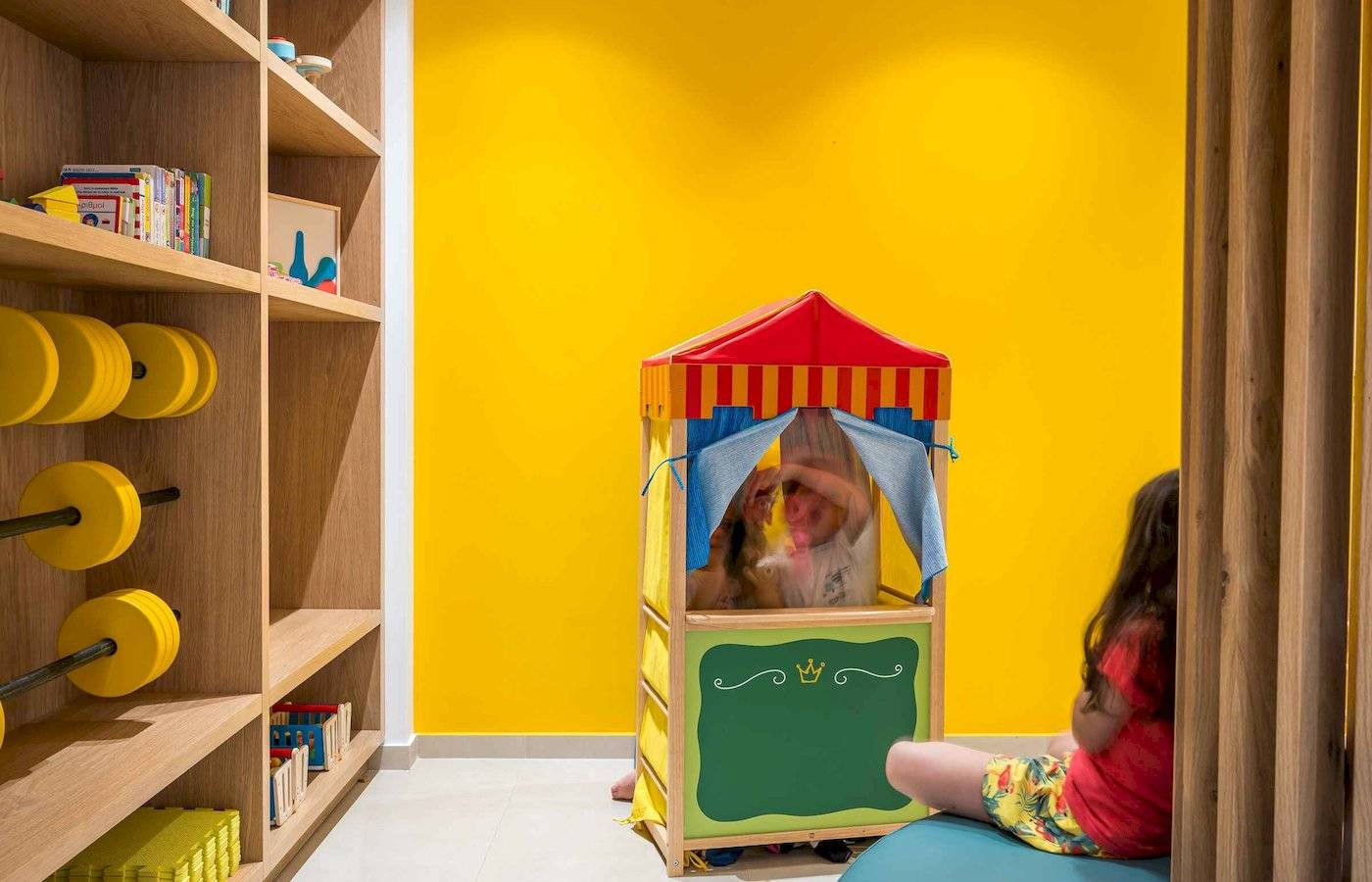 Im Arminda Hotel, Kinderzimmer mit einem Spielzelt und einem Bücherregal.