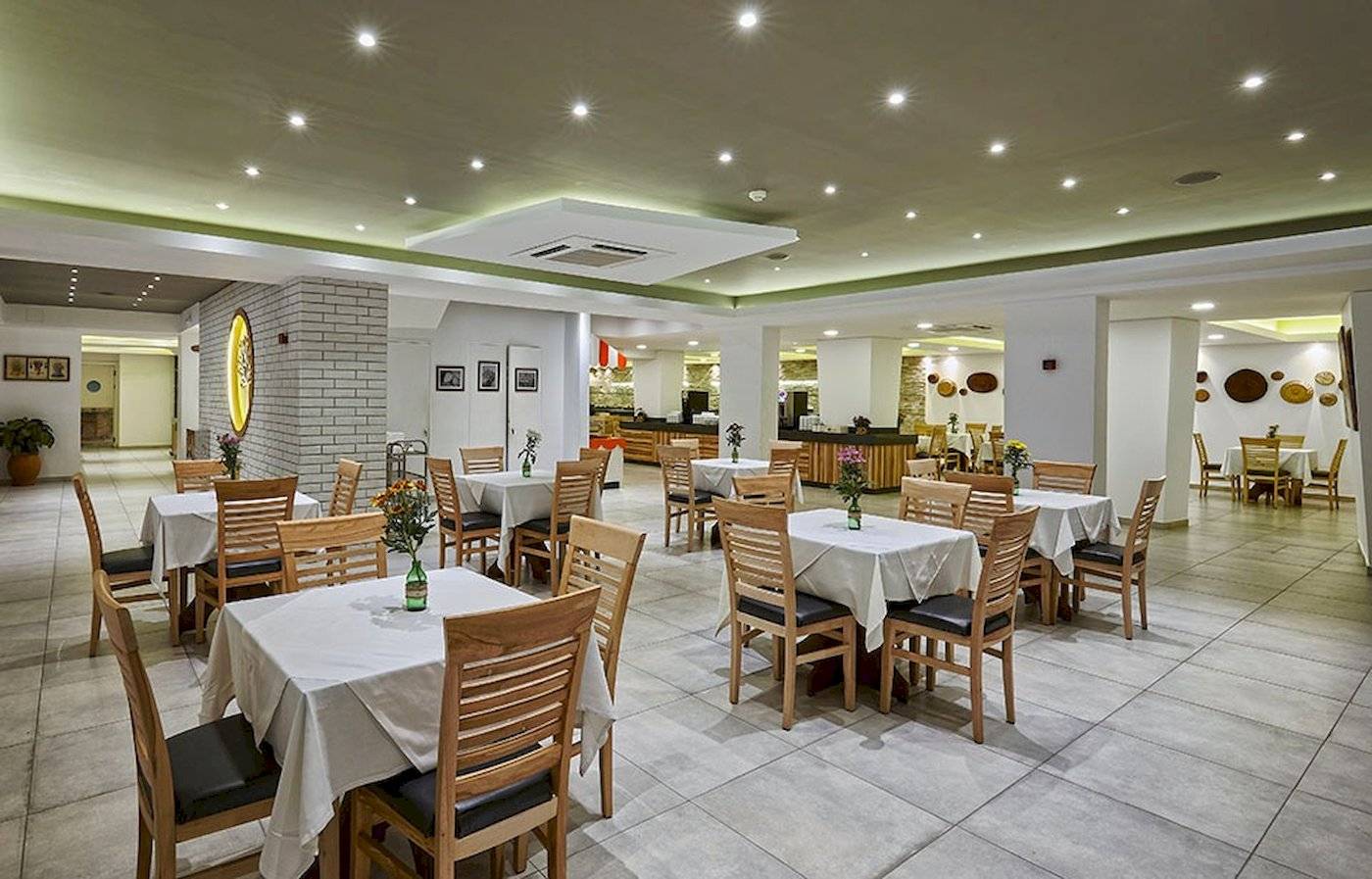 Arminda Hotel & Spa Innenbereich Restaurant mit weißen Tischen und Stühlen.